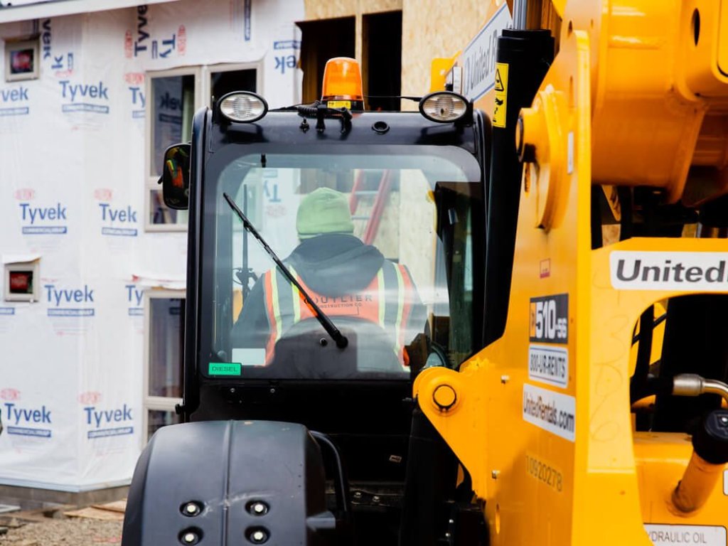 Contractor in excavator on jobsite.